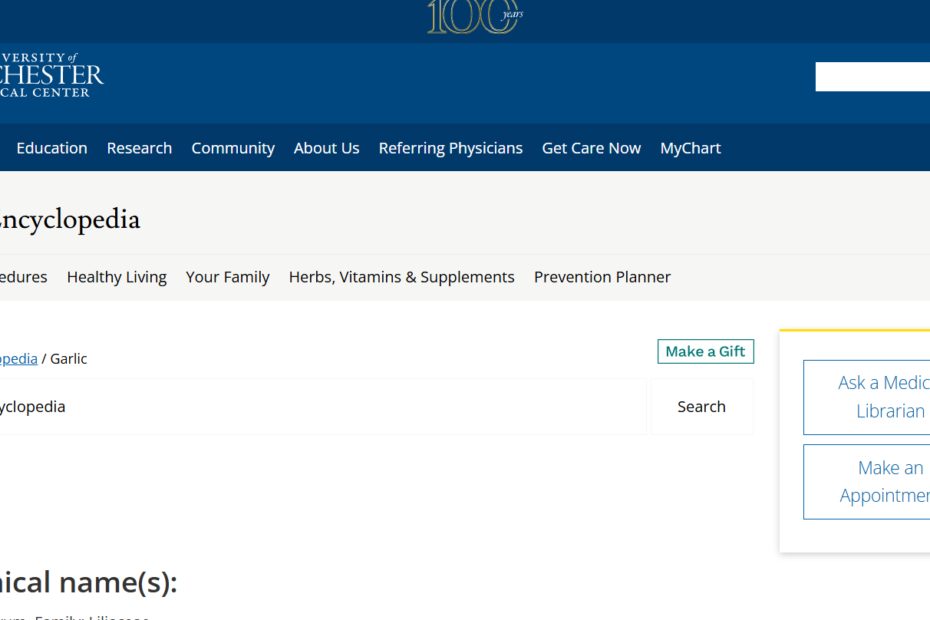 A professional close-up of several whole garlic bulbs and individual cloves on a wooden surface, one of which is crushed to show the release of oils. The image represents the natural and potent qualities of this herbal supplement.